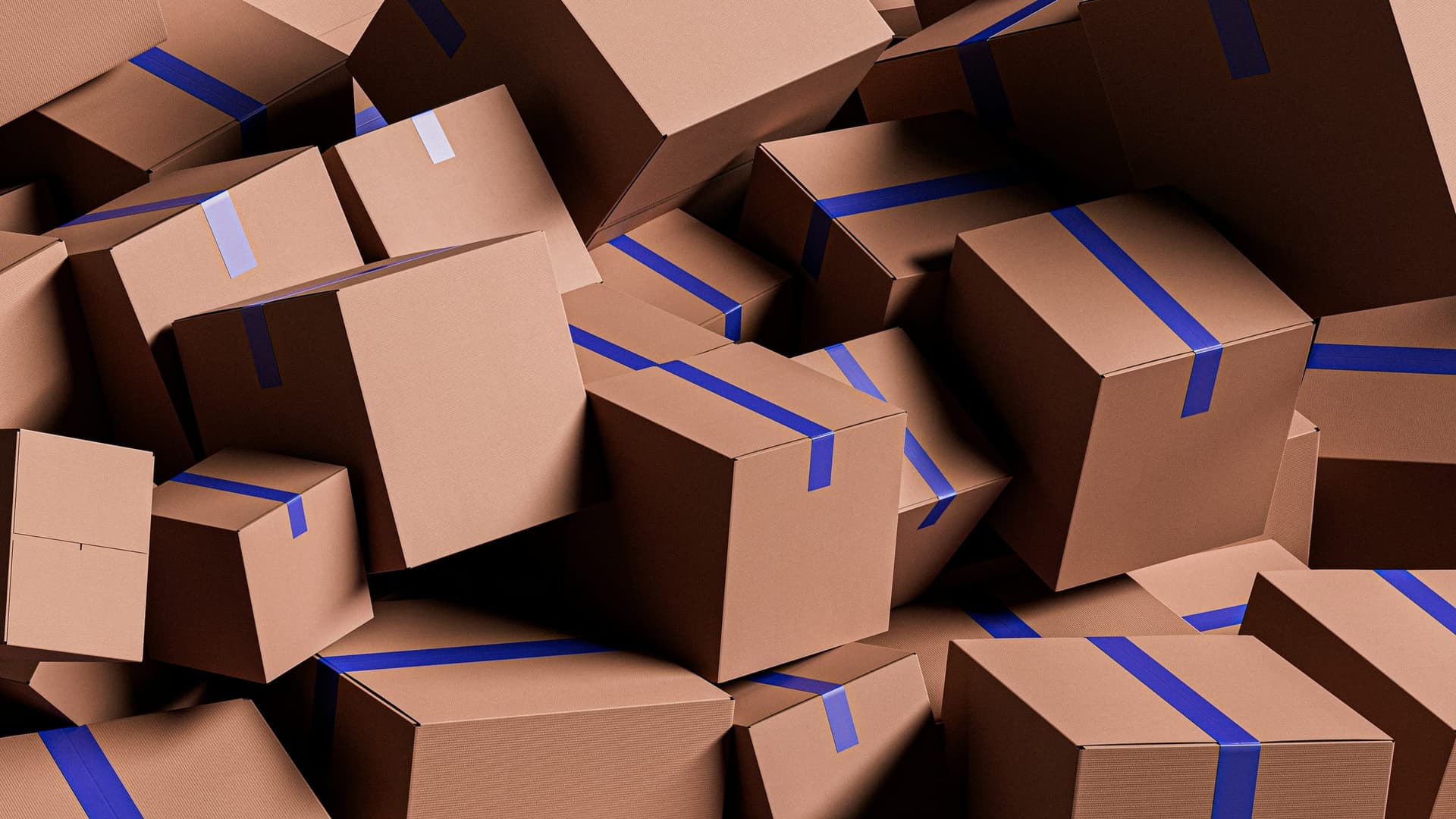 A large pile of brown cardboard boxes sealed with blue tape, stacked and ready to be moved