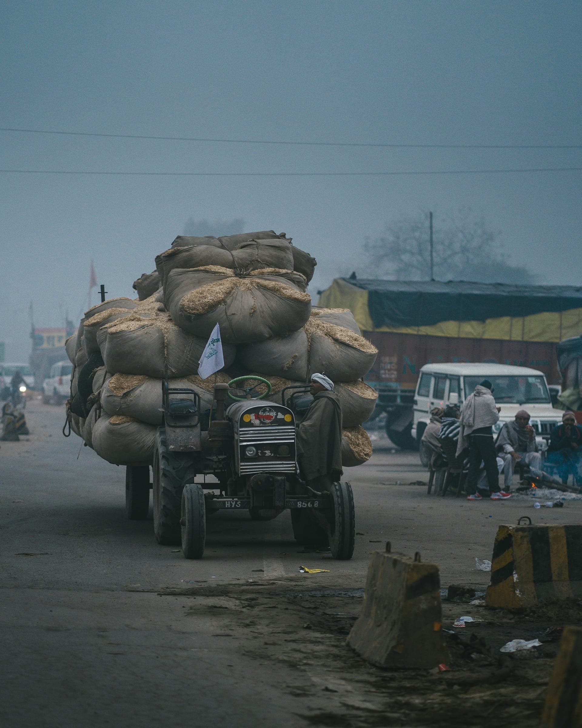 A truck loaded with sacks driving down a street
