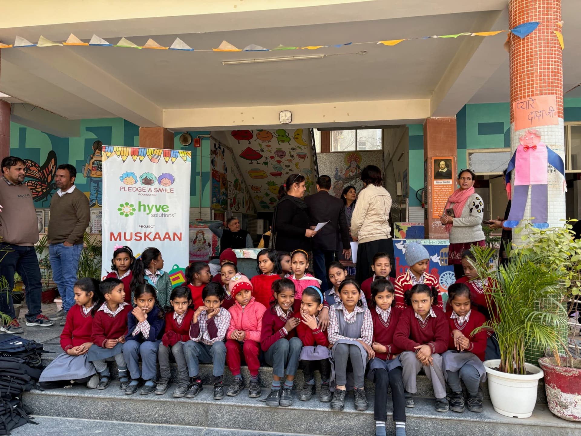 Children bundled in winter clothes seated on school steps - candid, unposed