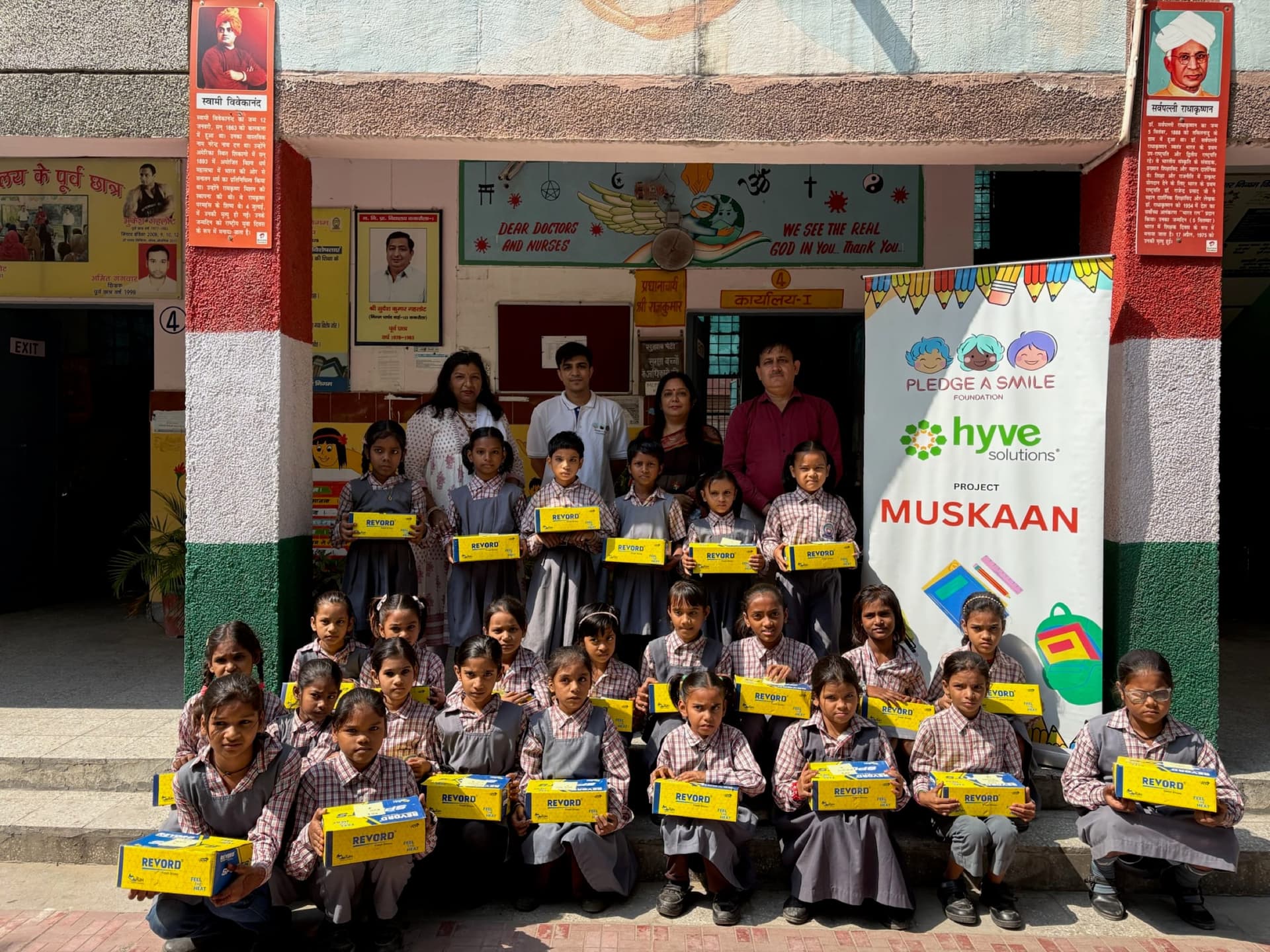 Girls' school group at tricolor entrance with Muskaan banner
