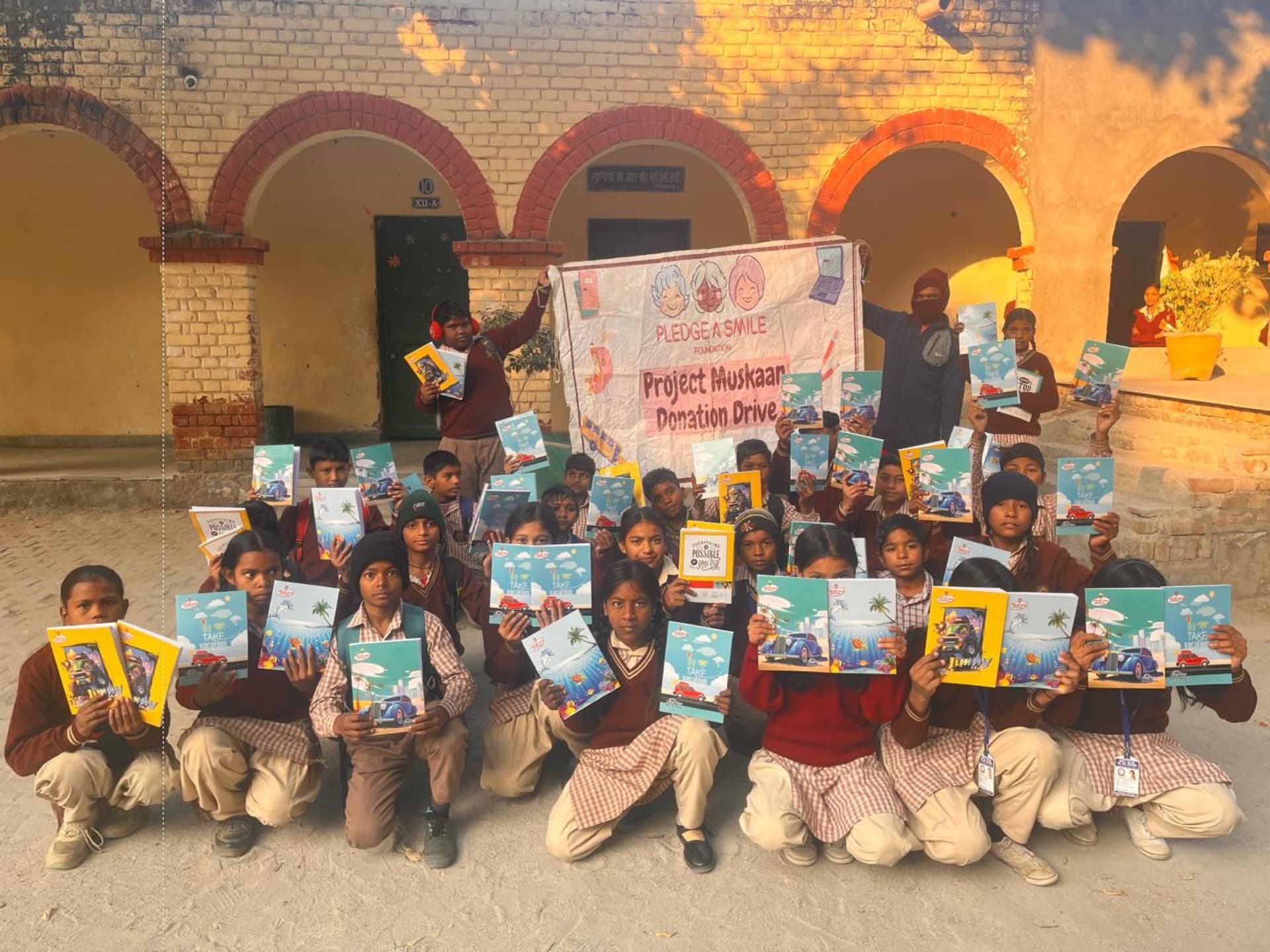 Kids holding notebooks aloft in a golden-hour courtyard, high energy.