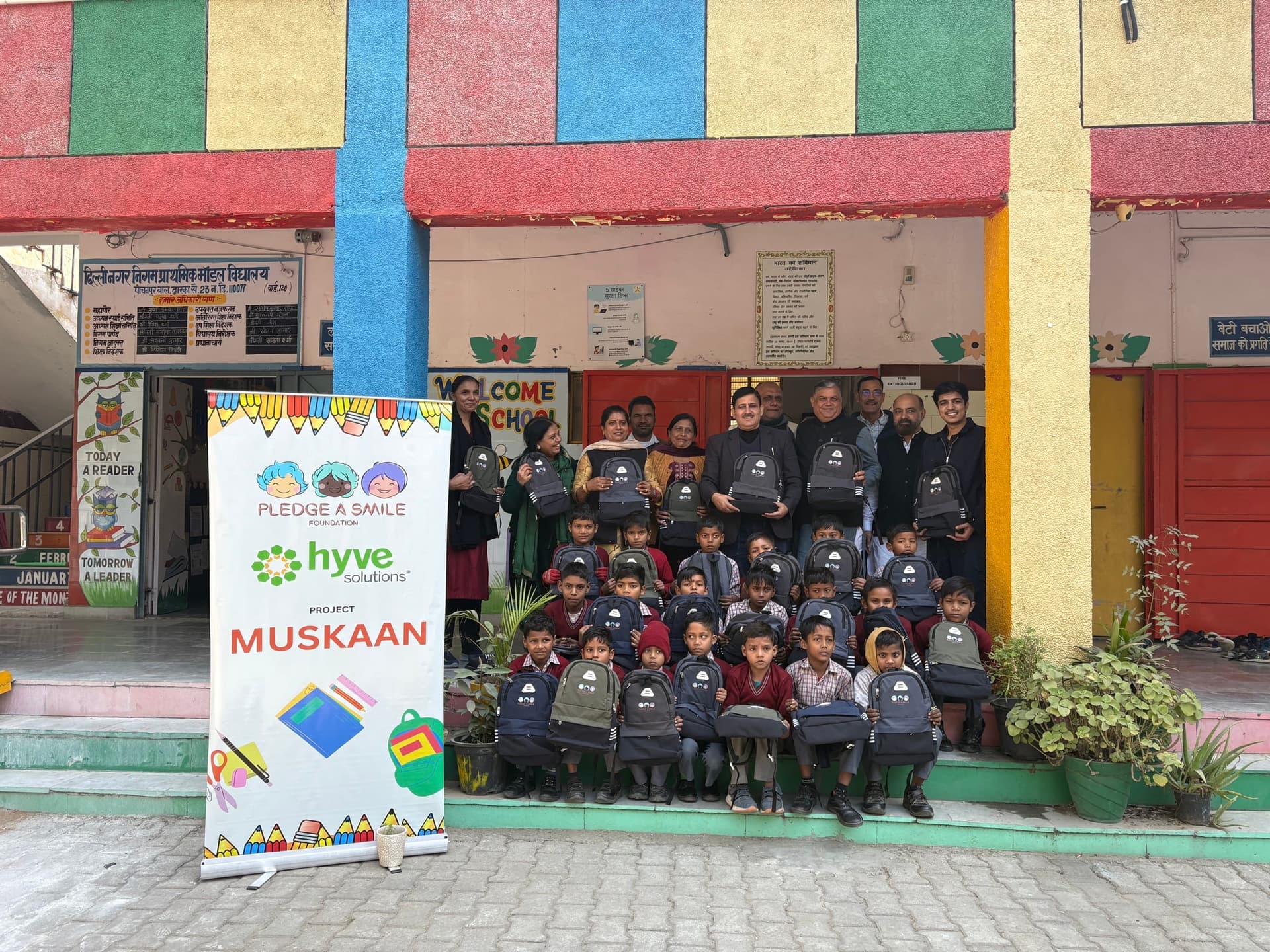 Backpack distribution at colorful Delhi Nagar Nigam school with Hyve banner
