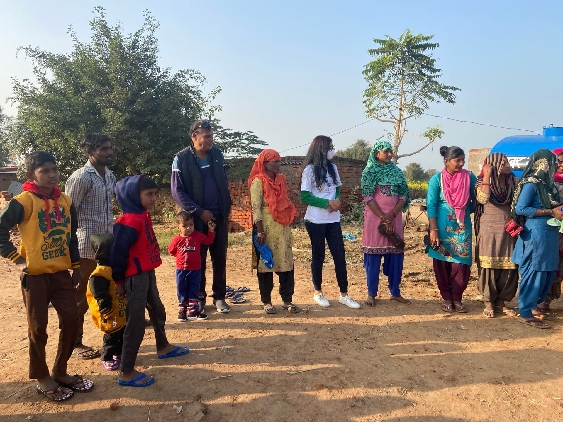 A community lineup receives new footwear in warm low sun