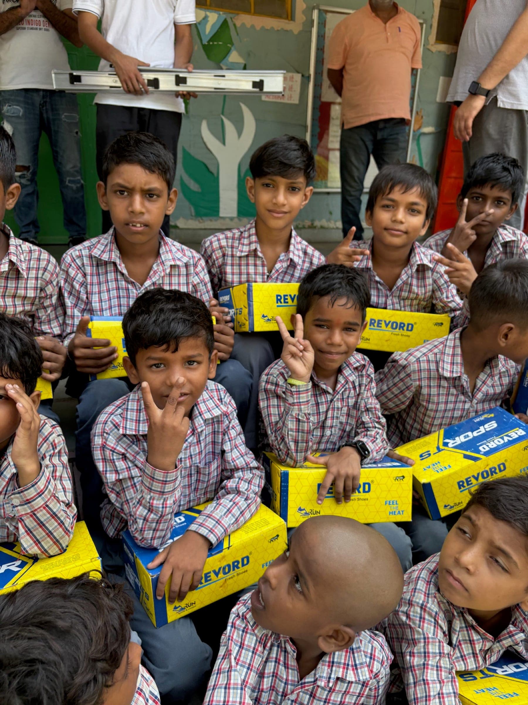 Boys grinning with peace signs over new yellow shoe boxes